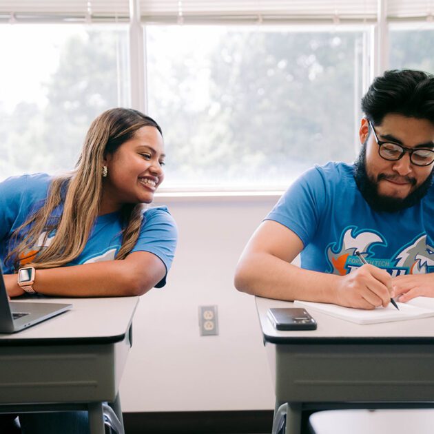 image of two staff members sitting at desks