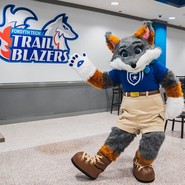 mascot blaze the fox in front of trailblazer sign