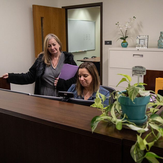 image of two staff members at desk