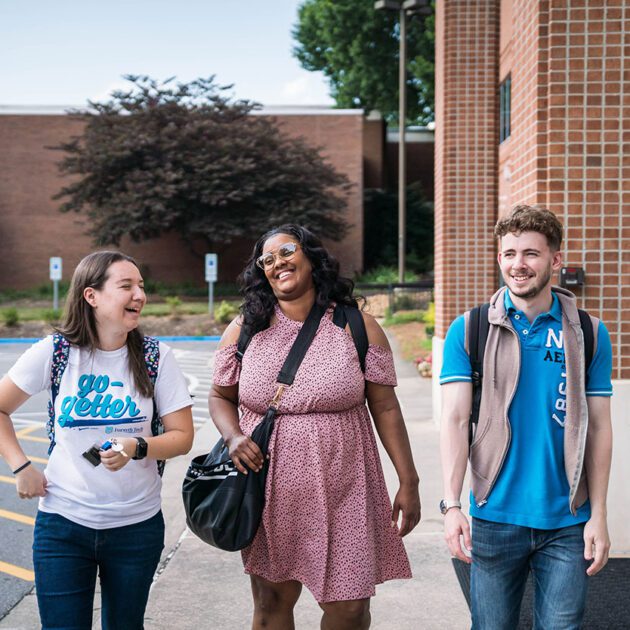 image of three students smiling walking outdoors