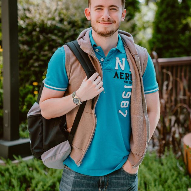student wearing bookbag standing outdoors