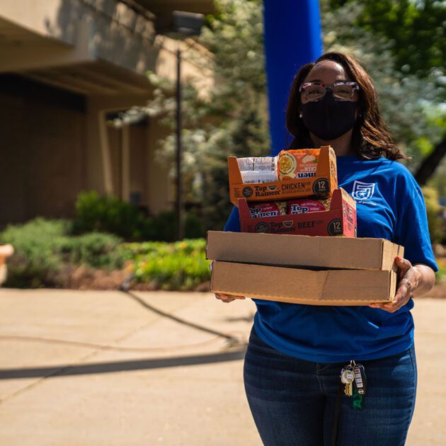 image of woman holding box of snacks outdoors
