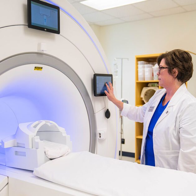 image of an MRI machine with professor in image