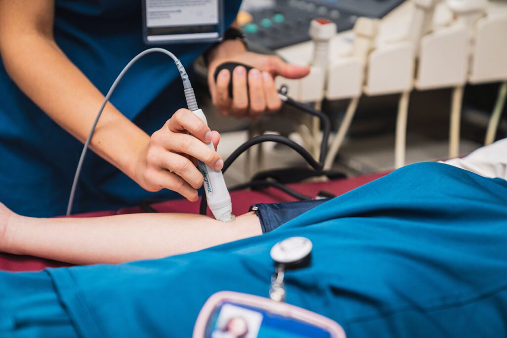 image of an ultrasound tech student using an instrument. Ultrasound tech is one of the programs approved for Workforce Pell.