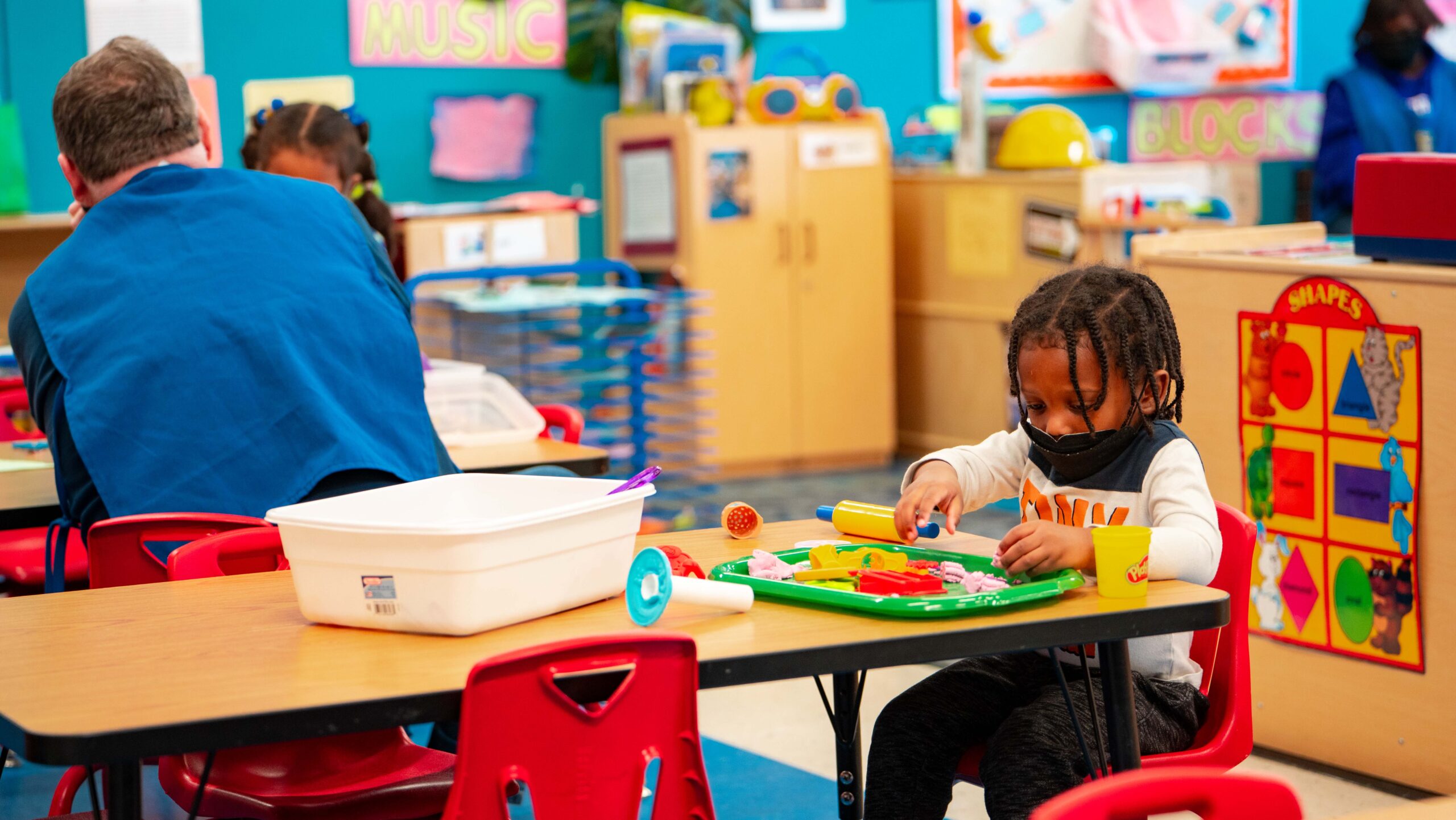 child playing with playdoh in a colorful daycare